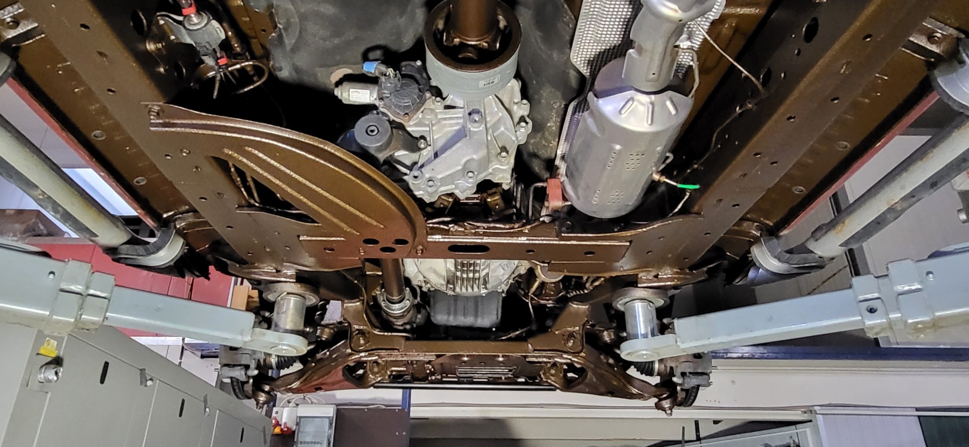 Auftragen von Unterbodenschutz auf der Hebebühne